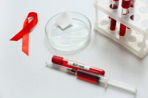 HIV blood test tubes, syringe and red ribbon