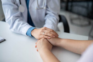 caring and kind doctor holding a patient's hands to comfort