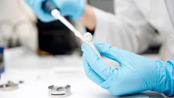 doctor taking sample with dropper from test tube