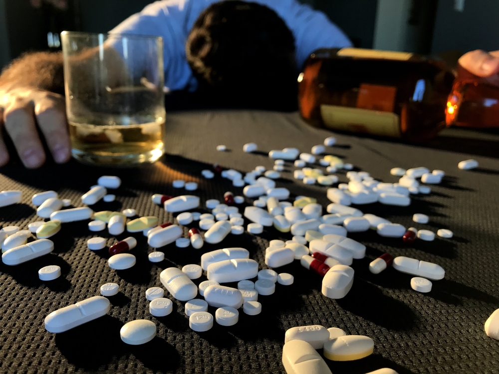 Man passed out from drug and alcohol use. Abusive use of legal drugs and alcohol. Vícios.