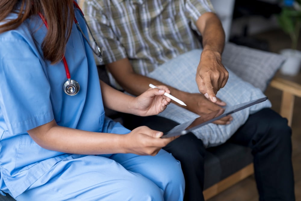 Doctor is showing medical test results on a digital tablet to a senior patient