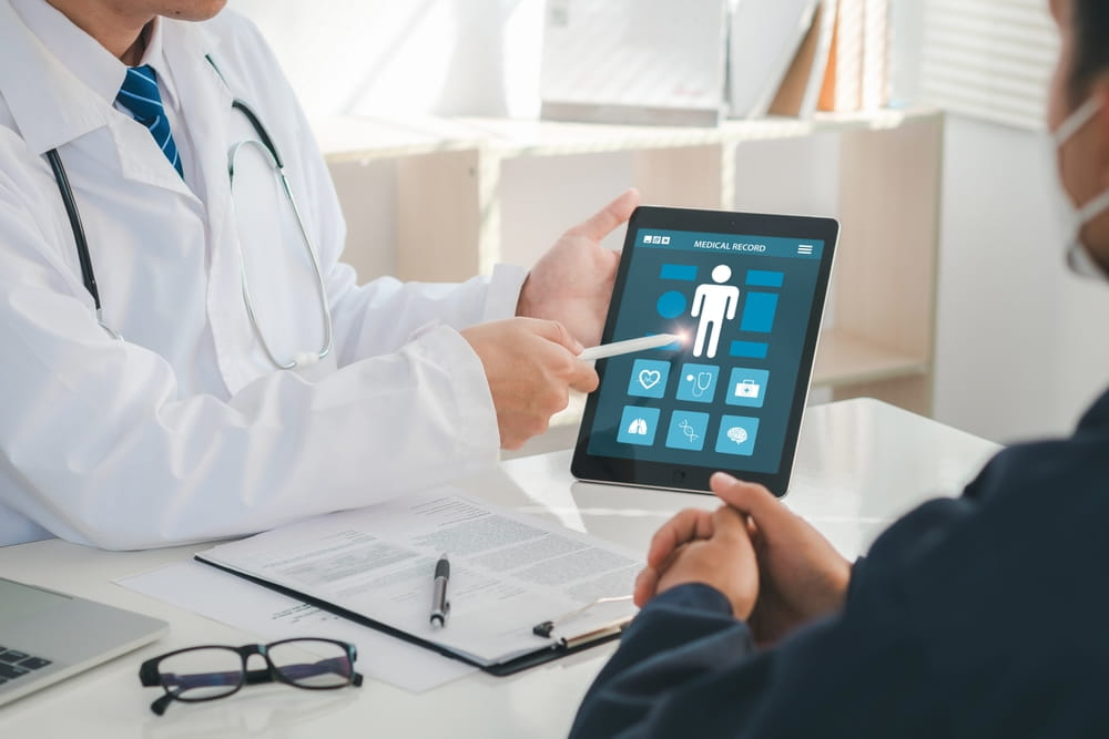 Medicine, healthcare and people concept. A doctor is showing a patient's medical record on a digital tablet