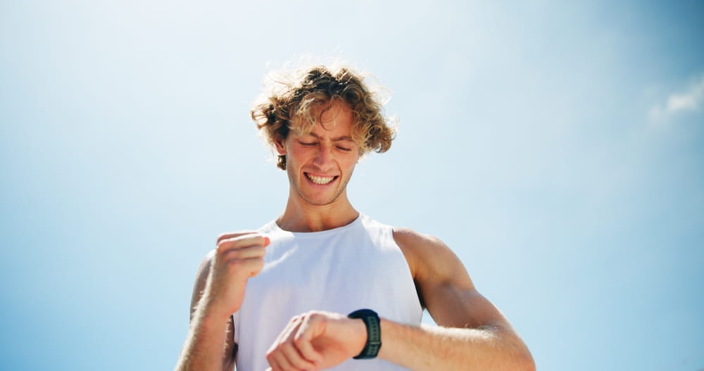 Smile, outdoor and man with fitness, smart watch and track progress with space, cheering and exercise
