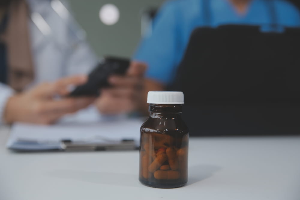 Asian psychologist women pointing on pills bottle to explaining medicine and prescription to female patient