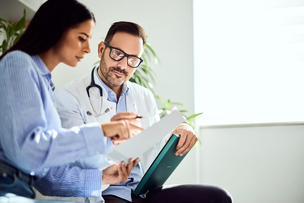 A physician discusses medical results with a patient in a professional healthcare environment.
