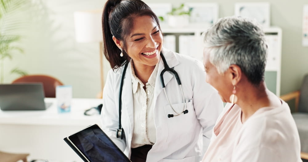 Mature woman, doctor and tablet for xray, support or conversation with cardiology checkup in office.