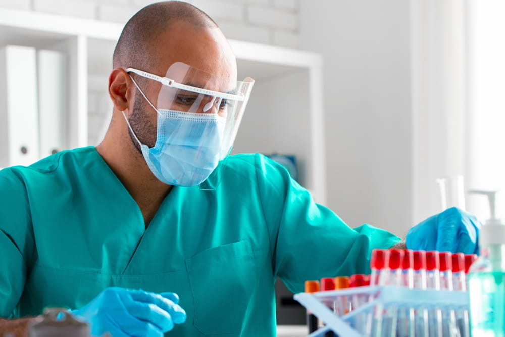 African american doctor or laboratory worker examines blood sample in clinic
