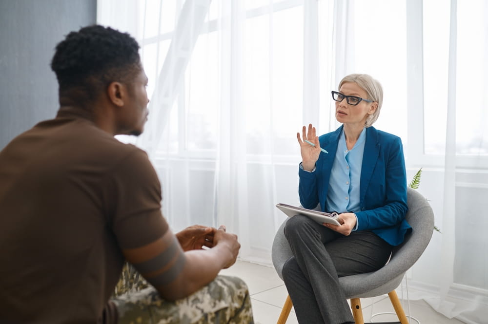 Professional psychologist giving advice to military patient