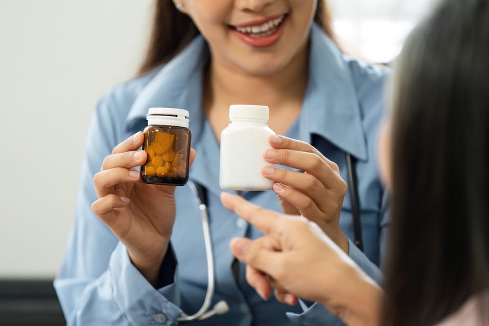 Medication Review and Patient Understanding. A healthcare professional is showing medication options to a patient during a health consultation.