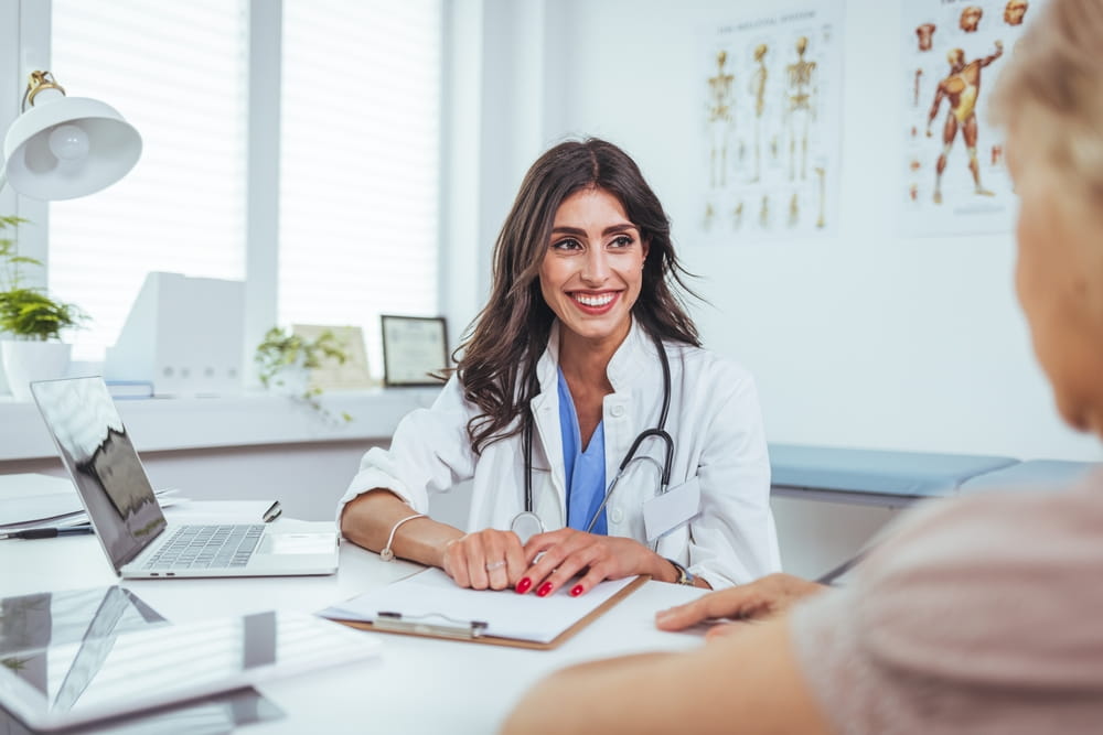 A friendly doctor engaged in a consultation with a patient in a well-lit clinic, fostering comfort and trust during the medical appointment