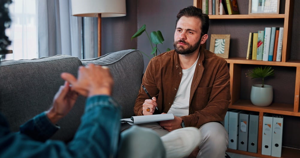 Counseling, therapist or man listening to client for help, mental health advice or support in office.
