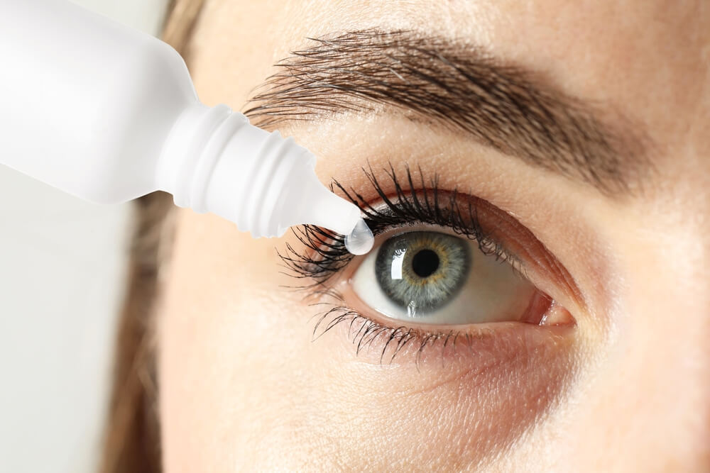 Woman applying eye drops