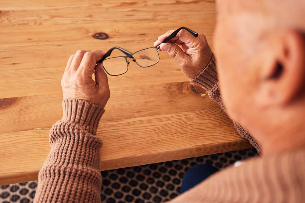 Senior man holding glasses