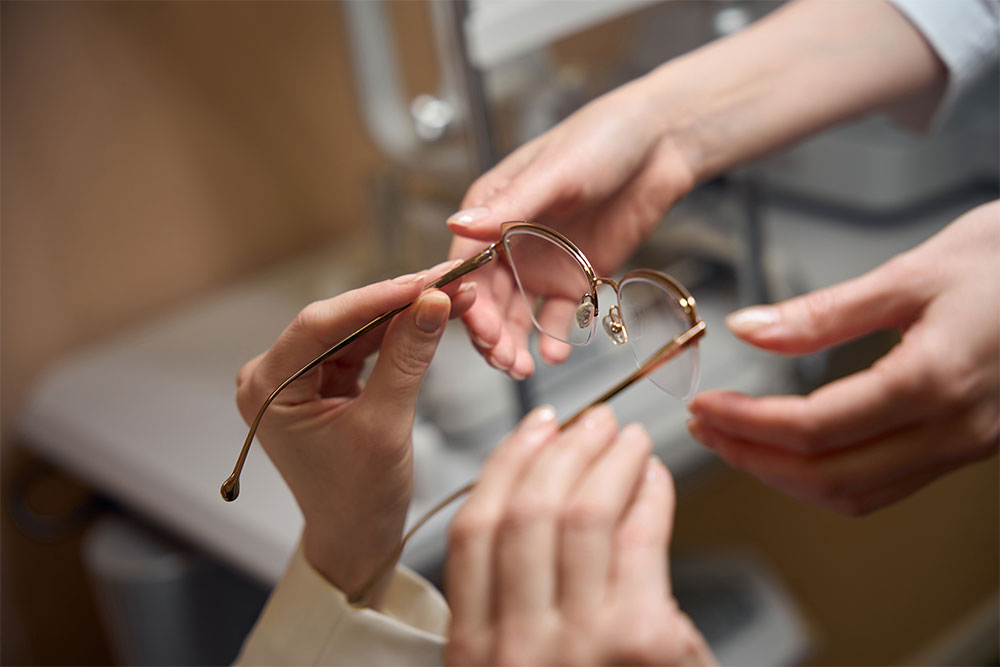 Woman passes glasses in a stylish frame to another woman