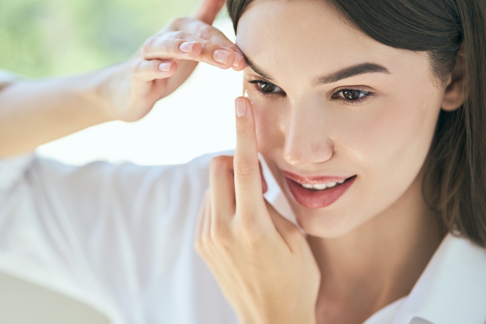 Woman Applying Contact Lens In Bright Room