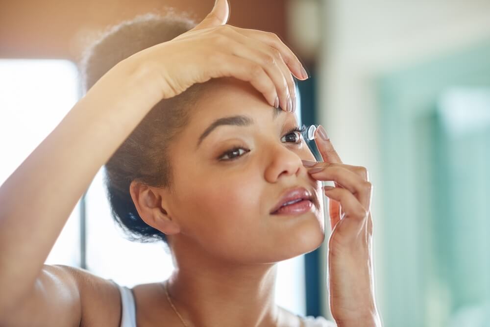 woman putting on contact lens