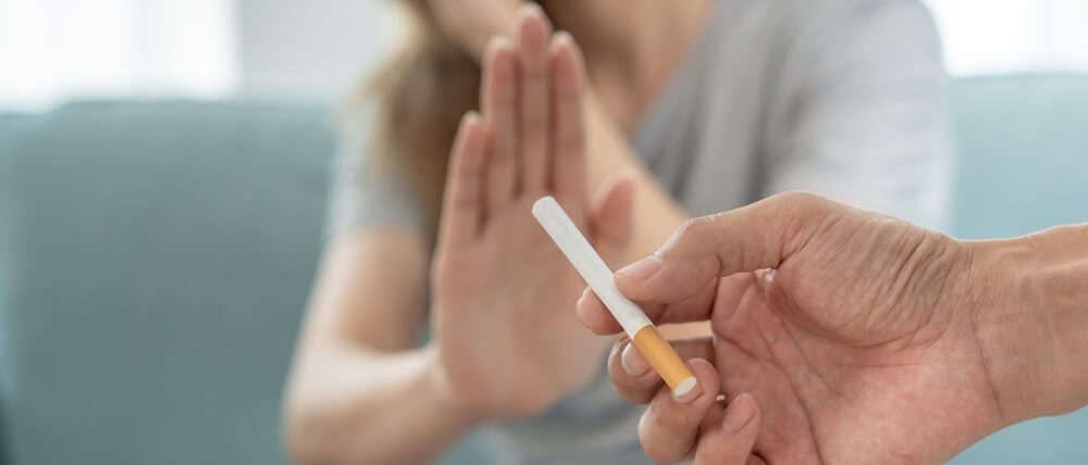 woman saying no to cigarette offered to her