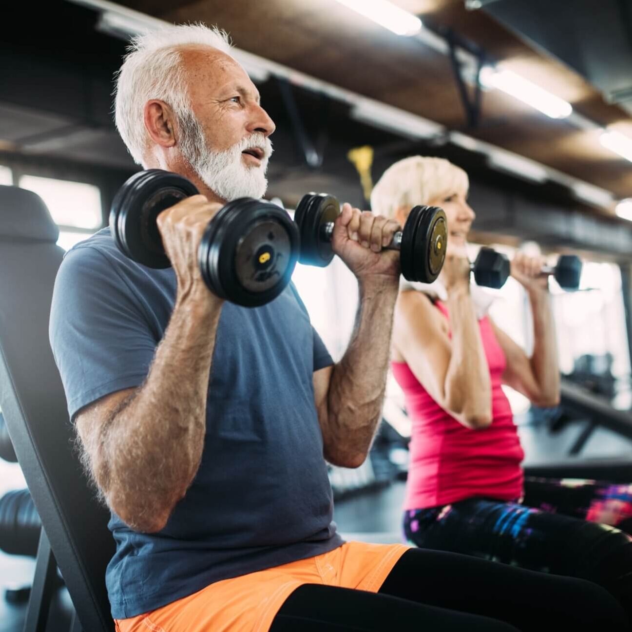 Happy senior people doing exercises in gym to stay fit