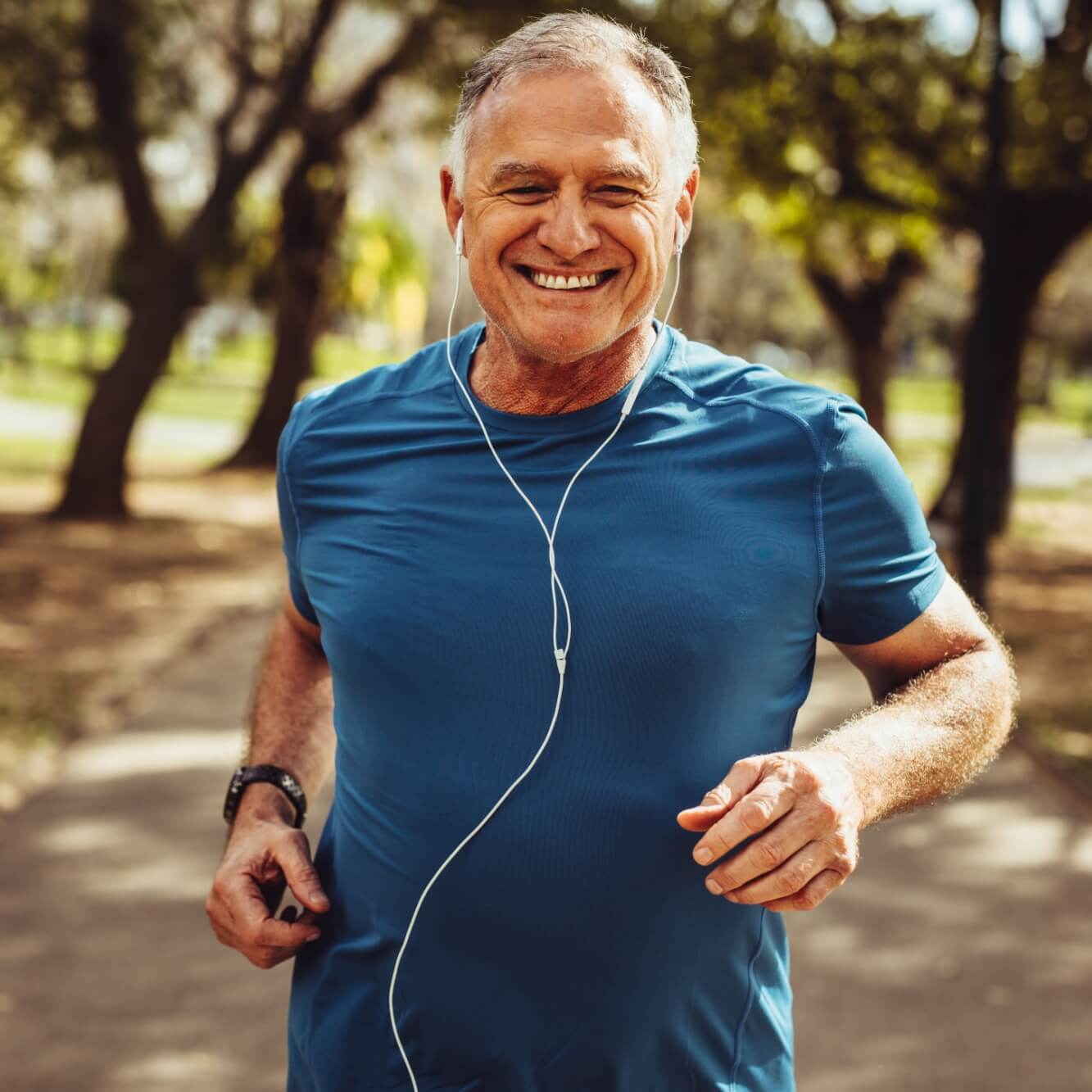 senior man in fitness wear running in a park