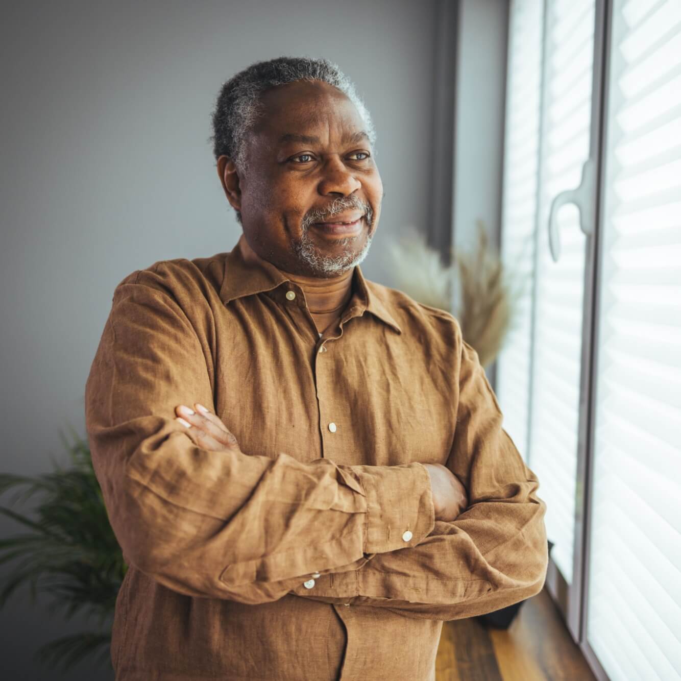 smiling senior man at home near window