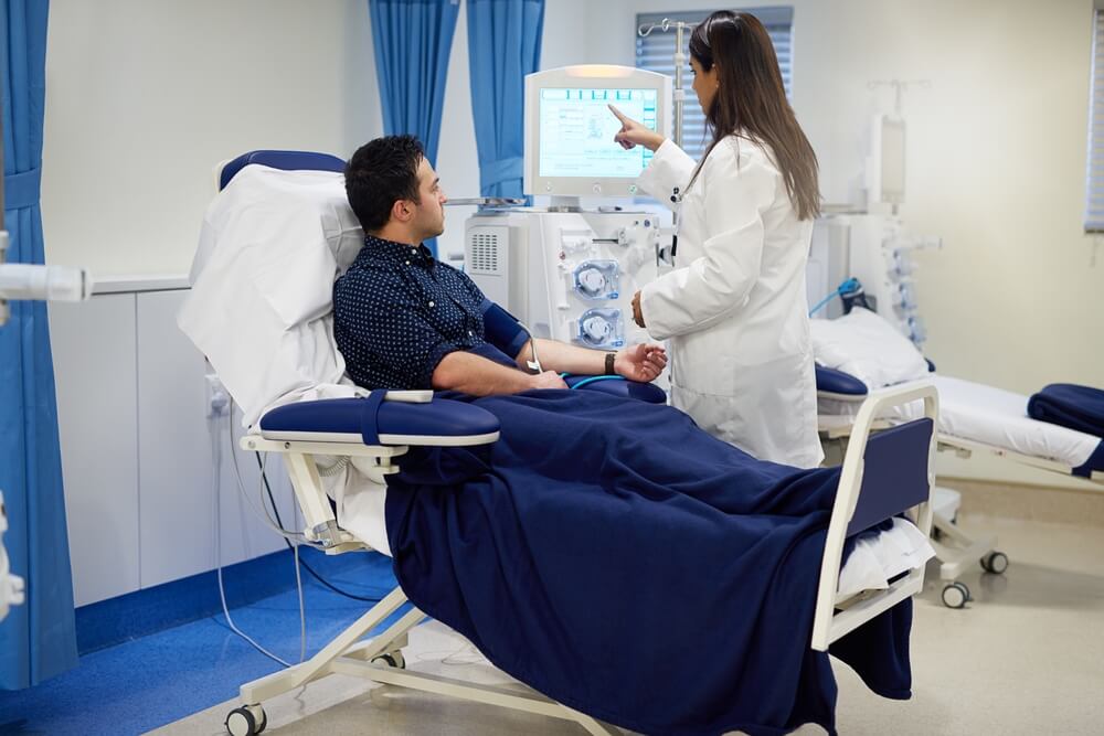 Man and female doctor with dialysis machine in hospital for kidney assessment