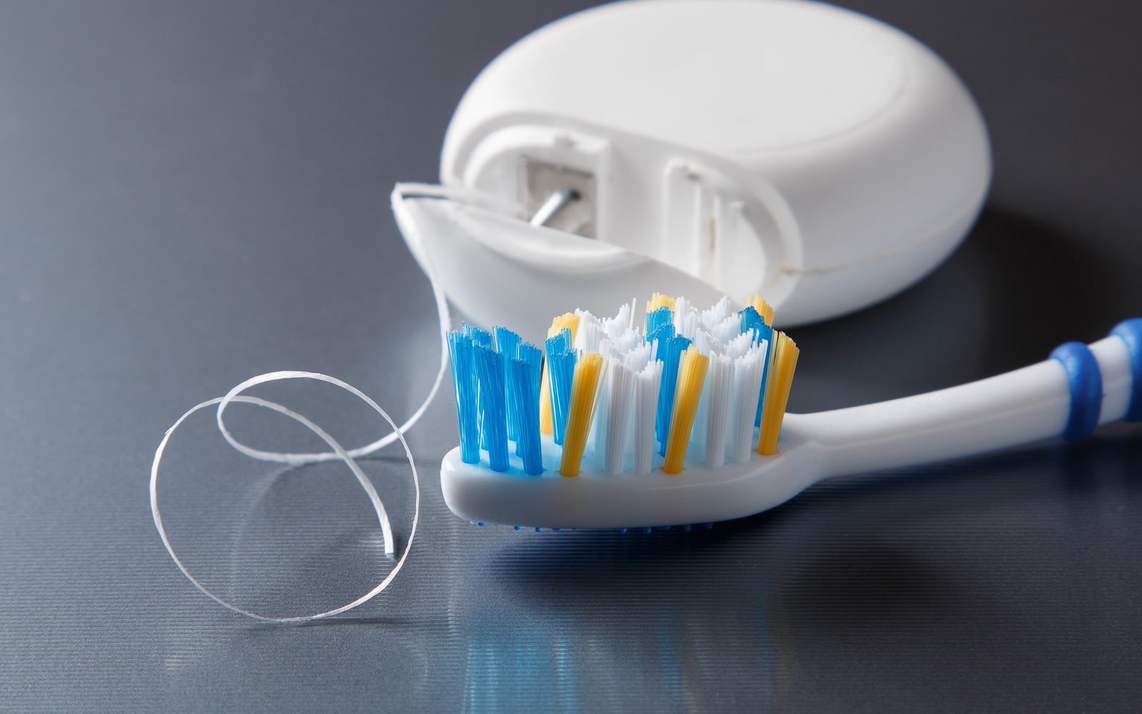 Flossing thread and toothbrush