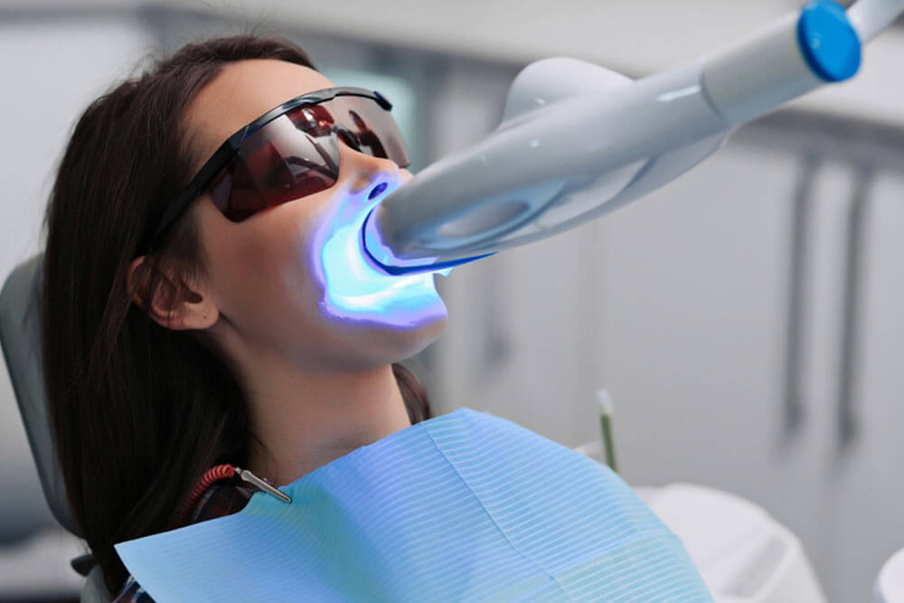 woman getting teeth whitening treatment