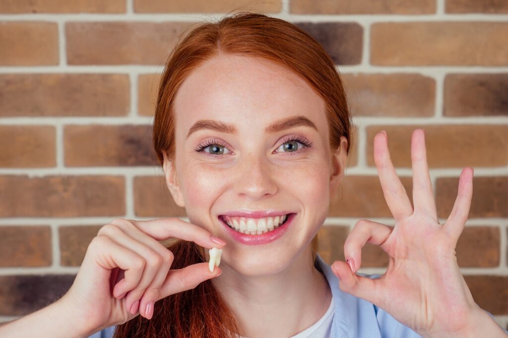 Young woman smiling with a toot model in her hand