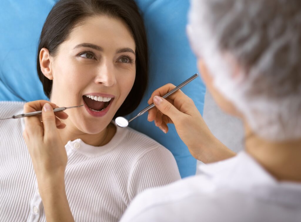 Smiling brunette woman being examined by dentist