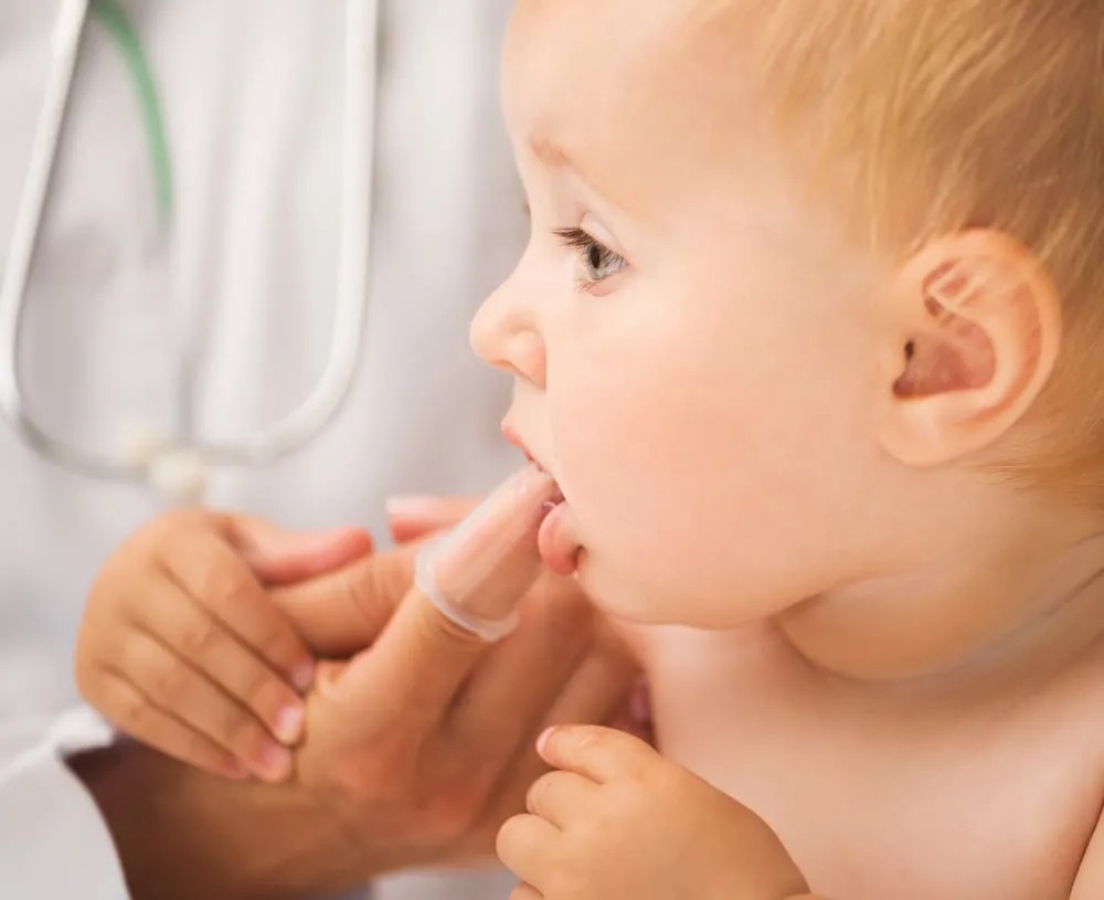 doctor cleaning baby`s mouth