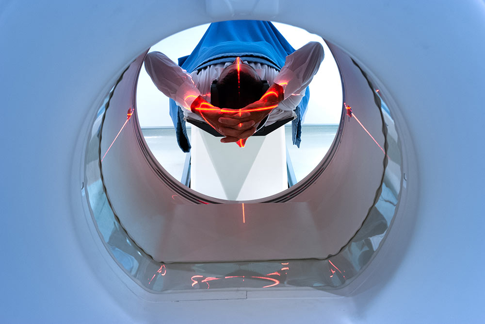 patient entering an MRI machine to produce a detailed and internal image of their organs