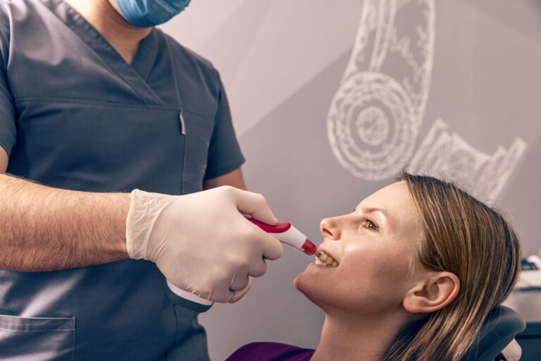 Dentist selecting patients teeth color with digital shade guide teeth color comparator