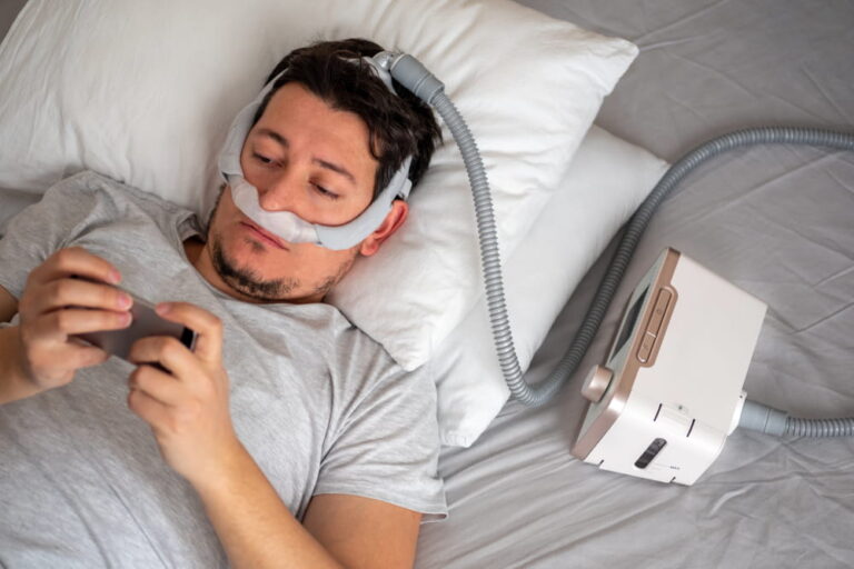 young man wearing under the nose nasal mask and using CPAP machine for sleeping smoothly