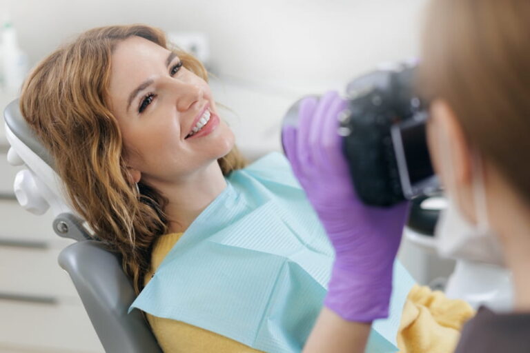 Dentist photographing of teeth woman client after treatment at dental clinic.