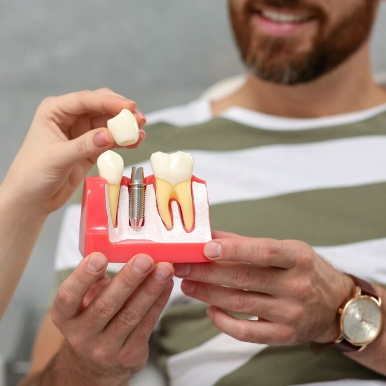 Doctor showing patient educational model of dental implant