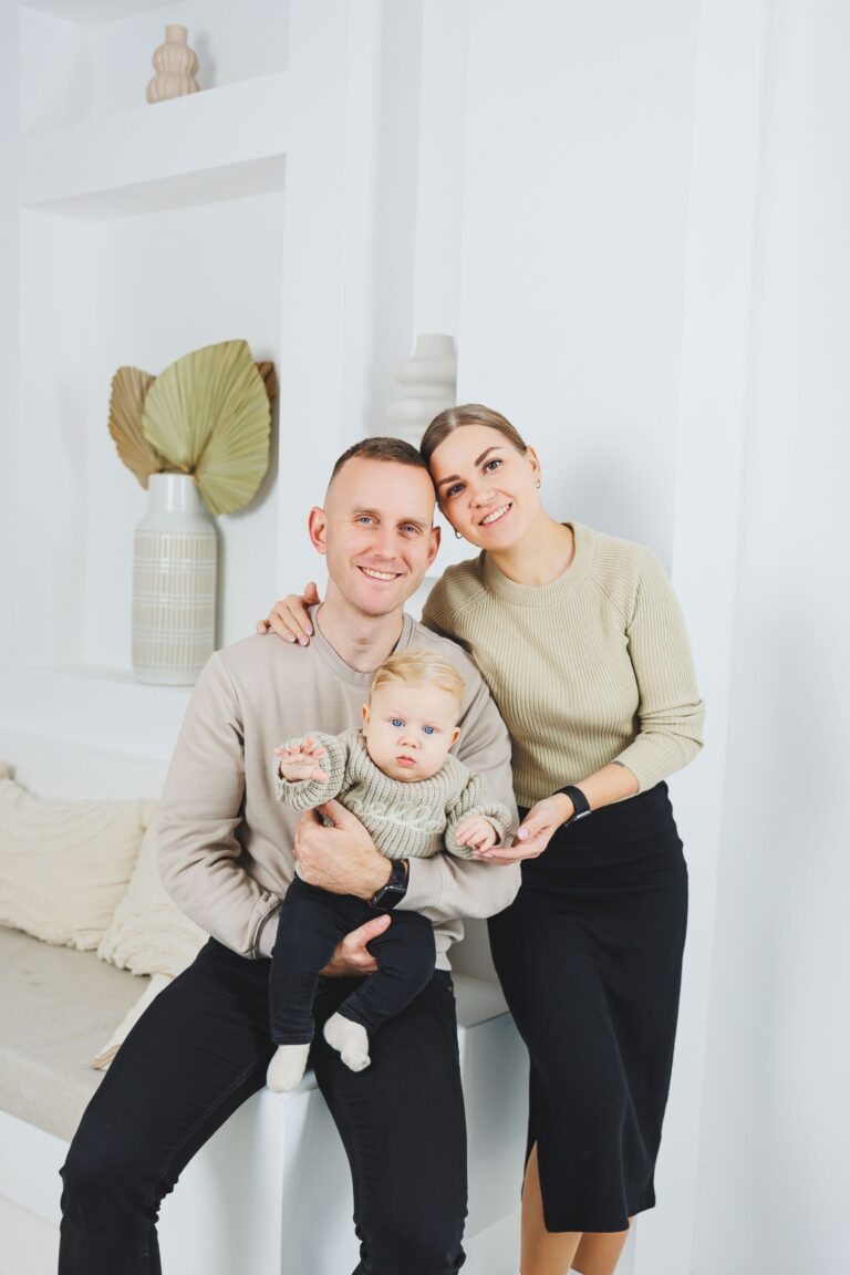 A family with a baby in their arms at home