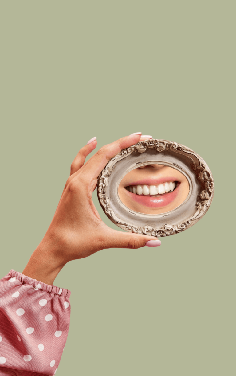 Woman lookint her teeth in mirror after treatment