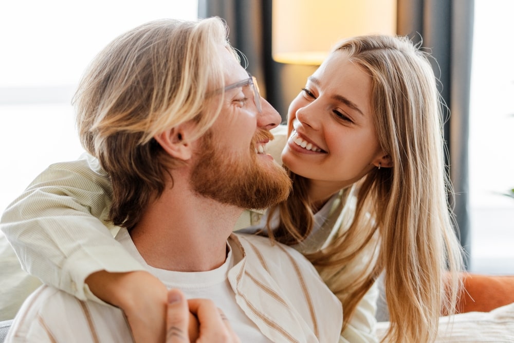 Happy young couple cuddling on the sofa at home