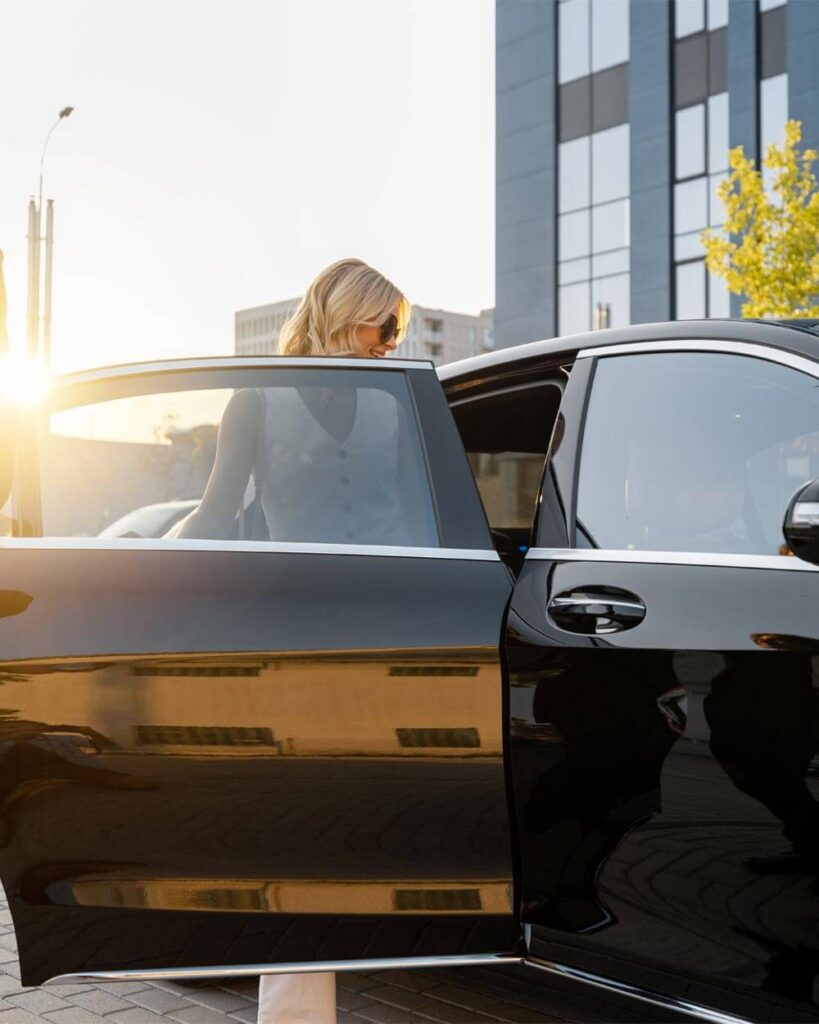 Woman being assisted into a luxury black car for private post-surgery pick-up service in San Diego