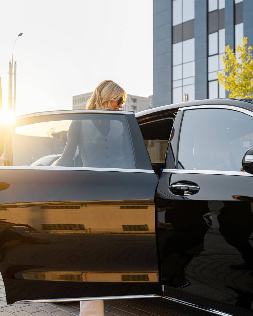 Woman being assisted into a luxury black car for private post-surgery pick-up service in San Diego
