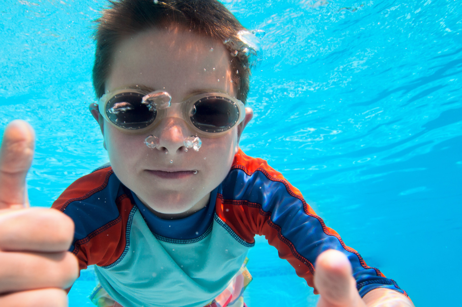 Child swimming under the water with goggles on.
