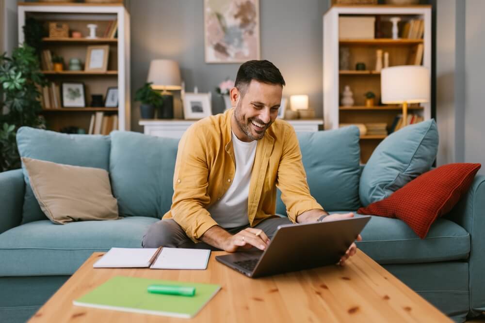 Happy man working from home on a laptop