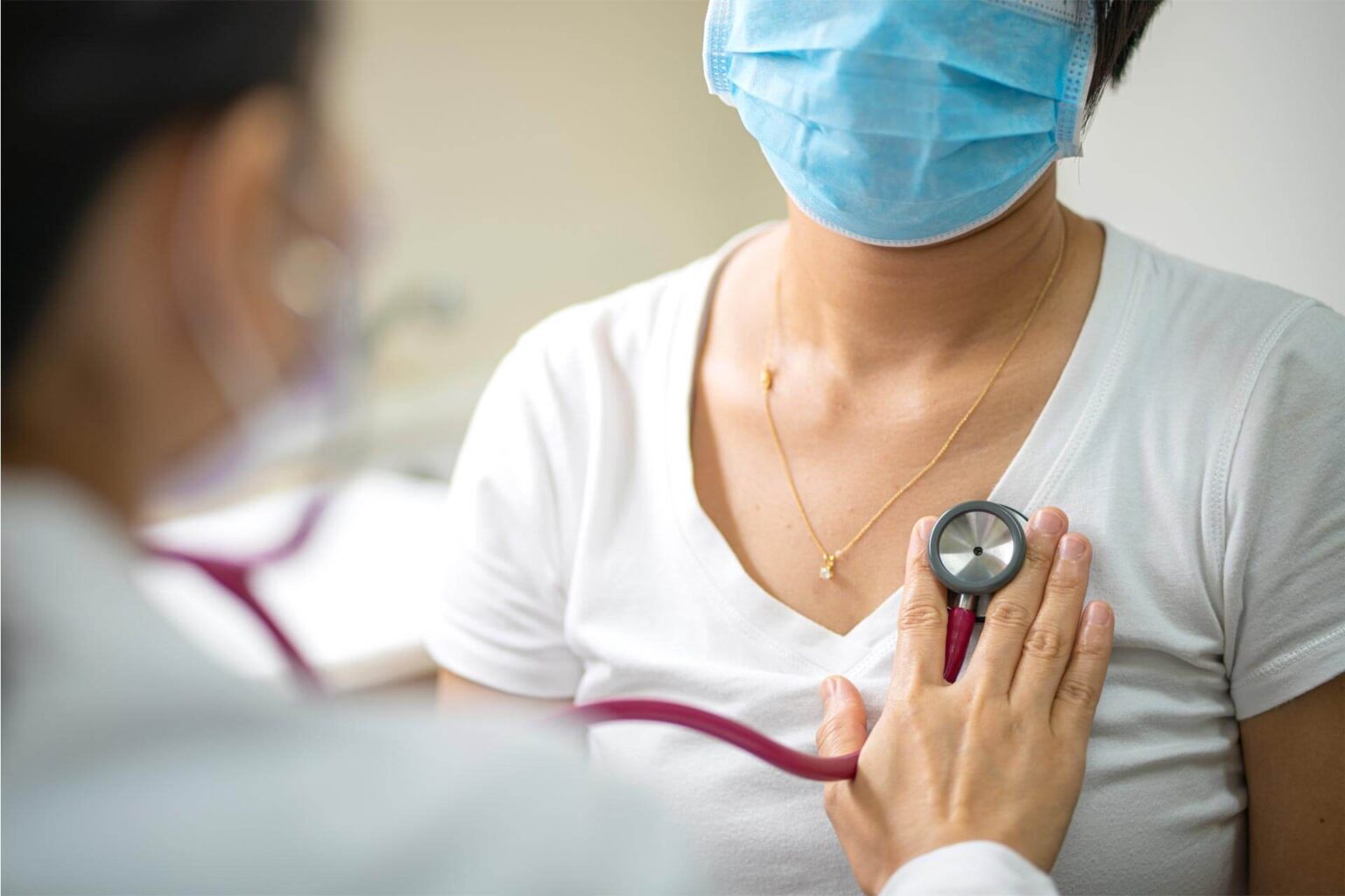 Doctor using stethoscope to examen female patient for upper respiratory infection