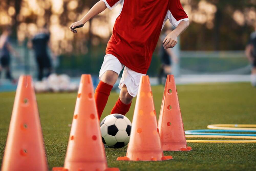 Young football player training on pitch