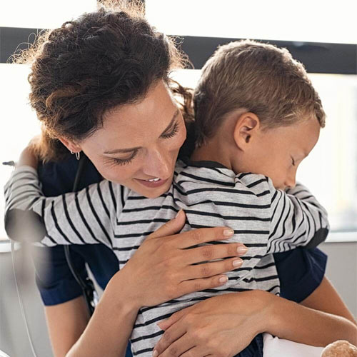Nurse hugging sick little boy patient in hospital