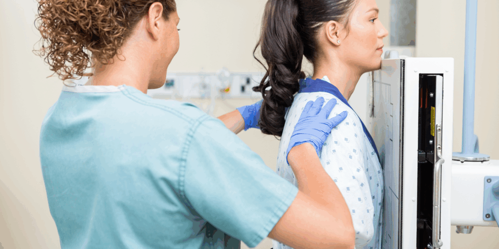 x-ray technician positioning a patient for a chest x-ray