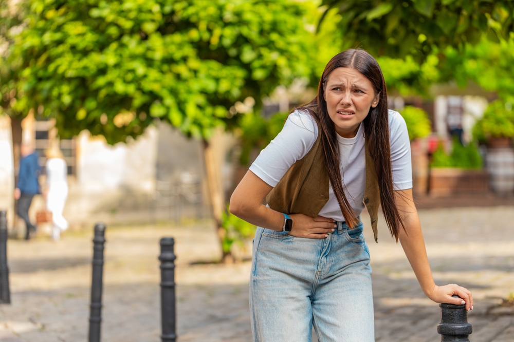 Caucasian young woman traveler feeling sudden strong abdominal stomach ache gastritis problem