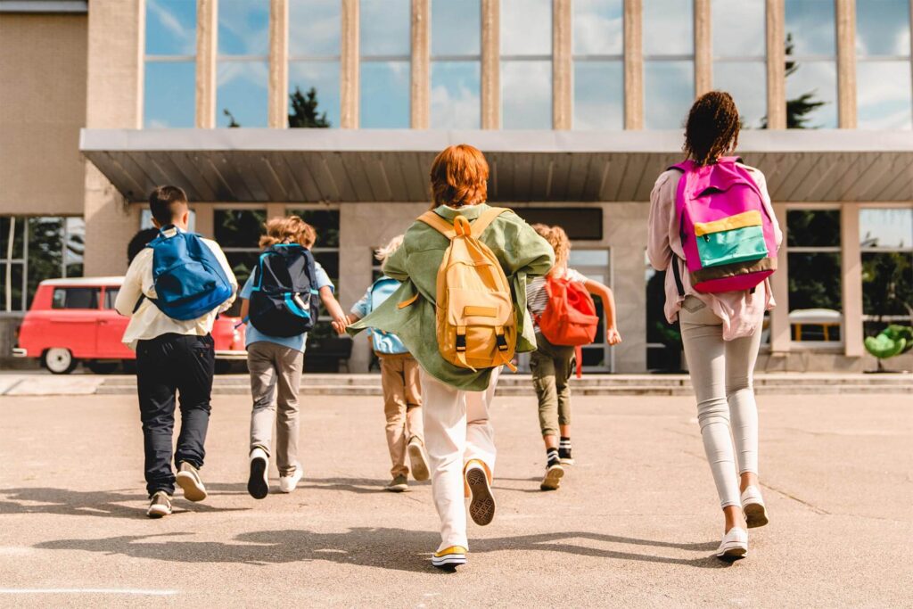 students running hurrying to the school building for classes