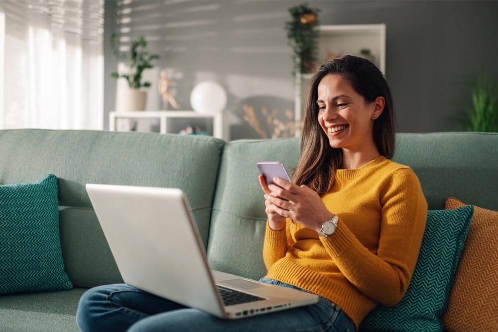 woman using laptop and a phone