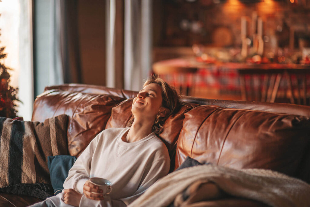 Young cheerful teen boy with long hair laughter and joyful at home